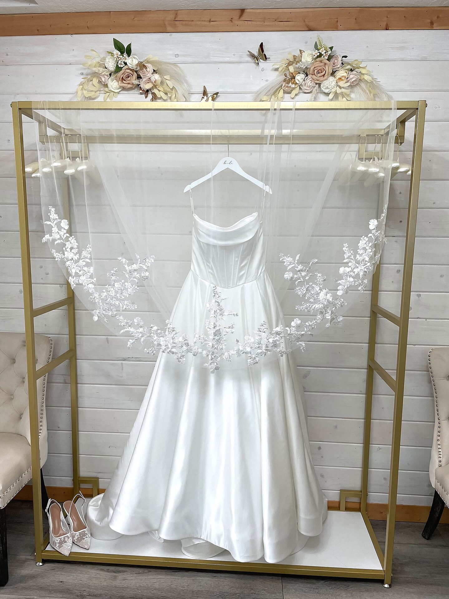 Wedding dress displayed on gold dress rack with lace veil spread in the Bride's Room at Sandy River Airport wedding venue Oregon