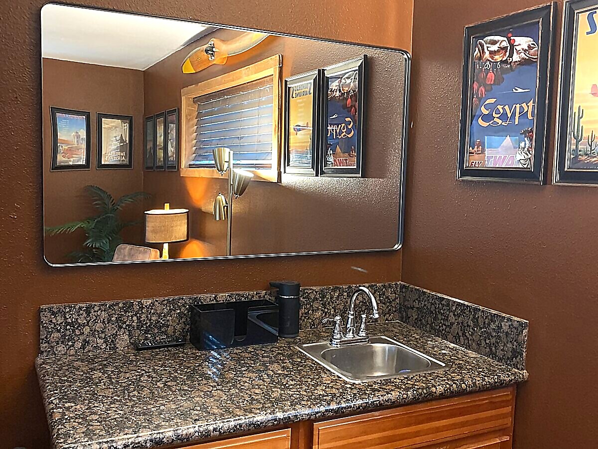 Groom's room vanity with granite countertop and TWA vintage aviation posters at Sandy River Airport